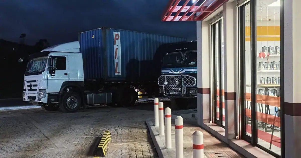 Station-service de nuit à Manjakandriana, avec deux camions sur la piste