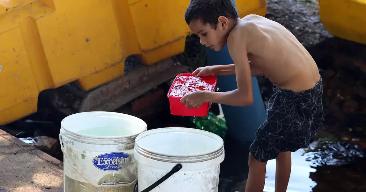 A boy collecting water in Bertrams, Johannesburg, after not having water in the area for days. PHOTO: ANTONIO MUCHAVE.