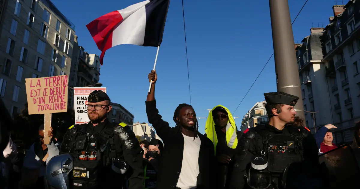 A demonstrator holds a French flag during a demonstration against rising living costs in Paris on Saturday.