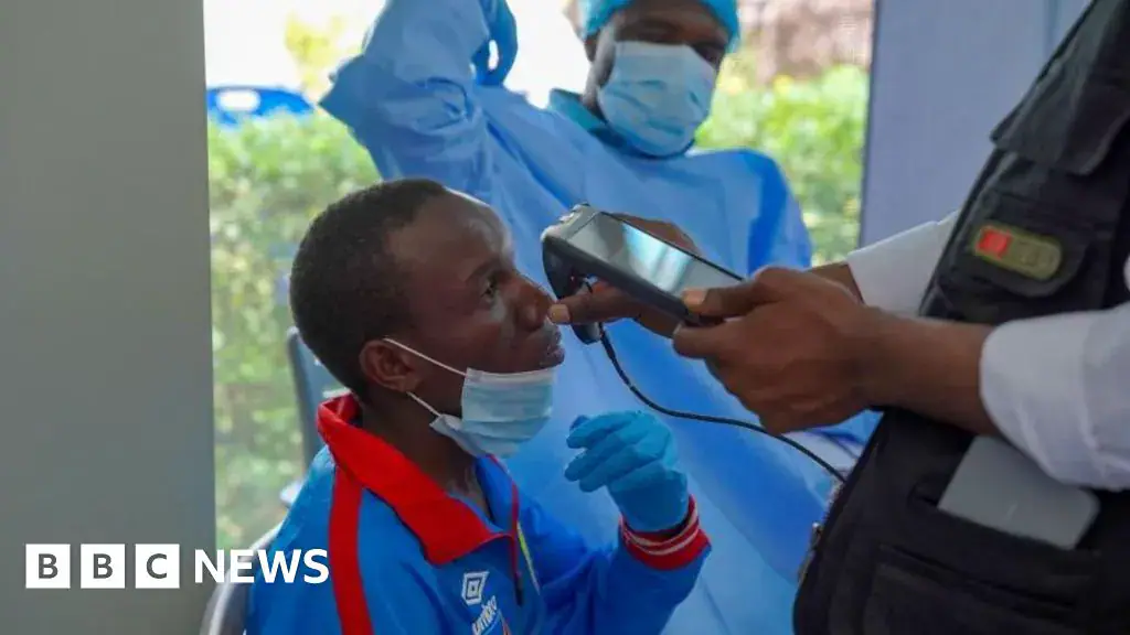 A man getting checked by a health professional who holds an implement up to him