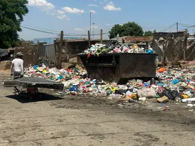 Grim: Sewage runs alongside homes and flies gather around the waste that has become part of everyday life . . . residents are still waiting for the basic services they say should have been provided long ago. Photos: Themba Maphanga