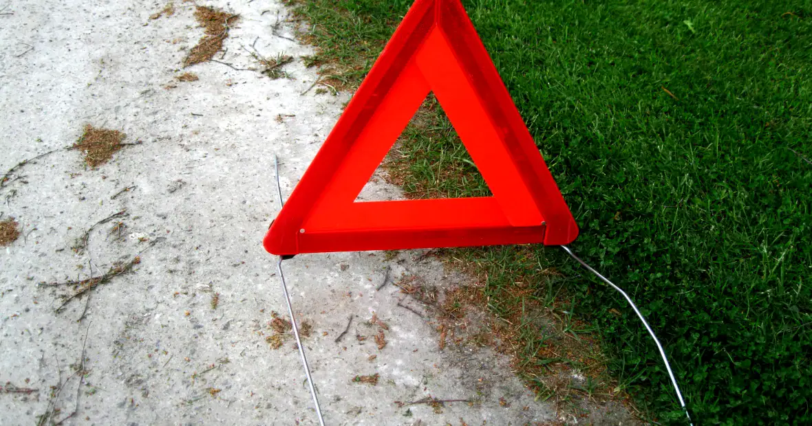Archive photograph of a red warning triangle beside grass, taken in 2016.
