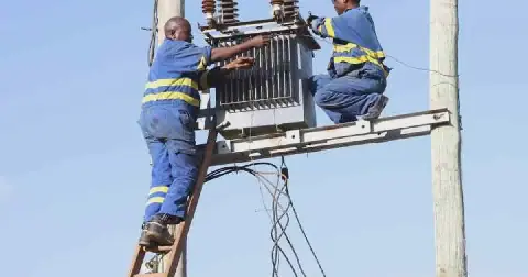 Kenya Power staff fixing a transformer