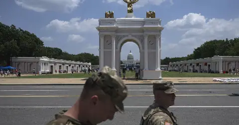 National Guard Members walk near a replica of President Trump's proposed arch at the Great American State Fair on the National Mall in Washington, DC, in July.