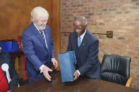 Leo Brent Bozell III, die VSA se ambassadeur in Suid-Afrika, oorhandig ’n geskenk aan oudpres. Thabo Mbeki op die vieringe van Amerika se 250ste jaar van onafhanklikheid in Pretoria.
