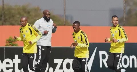 (Left to right) Thapelo Morena, Cassius Mailula and Fawaaz Basadien, watched by conditioning coach Kabelo 'KB' Rangoaga (background), warm up for a Bafana Bafana training session at UJ Stadium in Johannesburg on Monday.