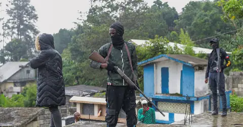 Men of the local defence force stand guard in a cemetery during a funeral service for people killed in an armed gang attack in Kenscoff, Haiti. Picture: Reuters/Patrice Noel