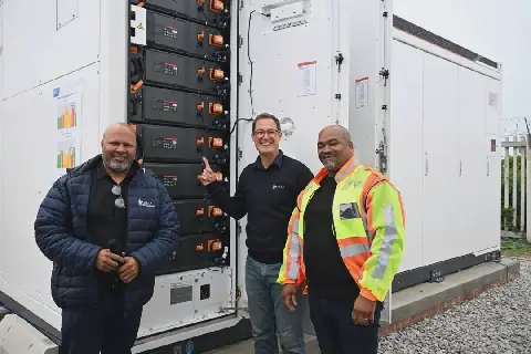 Die 2 MW-battery wat die Kouga-munisipaliteit gaan gebruik om kragkoste gedurende piektye te verminder. Theo Madatt, direkteur van elektriese en meganiese dienste, Hattingh Bornman, burgemeester, en Jaques Alexander, burgemeesterskomiteelid vir elektriese en meganiese dienste, staan by die reusebattery wat in St. Francisbaai geleë is.