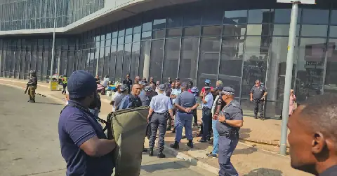 eThekwini metro police and members of the tactical unit talk to taxi bosses outside Oceans Mall in Umhlanga after a blockade brought the village to a standstill.