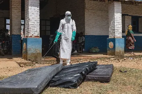 ’n Gesondheidswerker ontsmet matrasse van die kamer van ’n Ebola-slagoffer in Mongbwalu in die Demokratiese Republiek die Kongo.