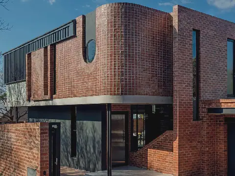 Die voorkoms van die huis is heeltemal getransformeer deur die byvoeging van ’n tweede verdieping met ’n treffende geronde baksteenfasade. Die eienaars het ’n moderne element ingebring met die gebruik van Storm Grey Saflok 700-plate op die fasade. “Dit word met knippe pleks van die gebruiklike skroewe of spykers aan die dakkappe geheg. Omdat geen gate dus gemaak word nie verminder dit die risiko van ’n lekkende dak,” verduidelik Renier. Dis maklik om te installeer en die plate word vooraf geverf.