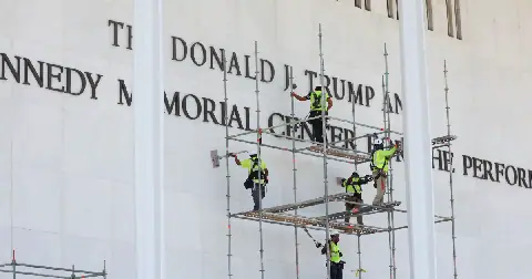 In December 2025, President Trump's name was added to the exterior of the Kennedy Center in Washington, D.C. Less than six months later, it was removed, following a judge's ruling that only Congress can change the name of the performing arts complex, which was established as a "living memorial" to John F. Kennedy. Above, workers stand on scaffolding outside the Kennedy Center in June.