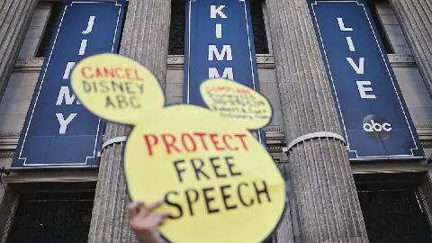 A demonstrator waves a "Protect Free Speech" sign following a protest against the suspension of the "Jimmy Kimmel Live!" show, held near the theater where the show is produced in Hollywood, on September 22, 2025 in Los Angeles, California.