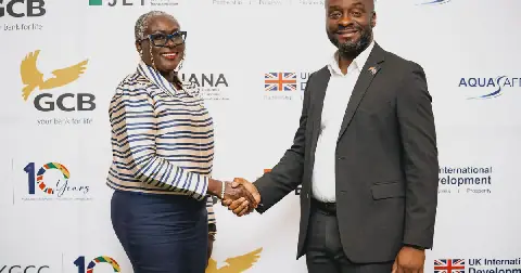 Executive Director of the UKGCC, Adjoba Kyiamah, in a handshake with Eugene T. Sangmortey, UK-Ghana JET Team Lead, at the launch of the Trade Resource Centre