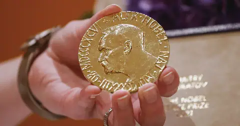 A woman holds Russian journalist Dmitry Muratov's 2021 Nobel Peace Prize medal in New York in 2022.