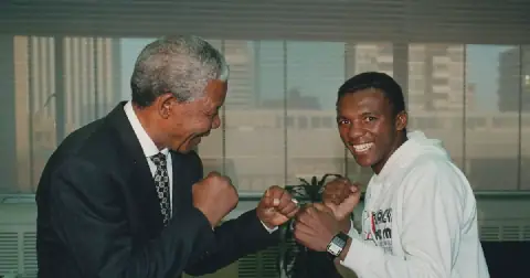 President Nelson Mandela displays his boxing skills with Dingaan Thobela.