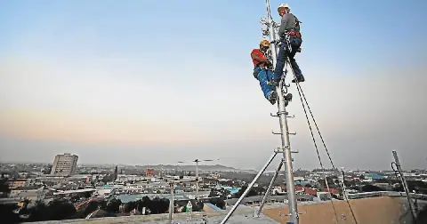 Technicians install a cellphone tower in East London. File photo.