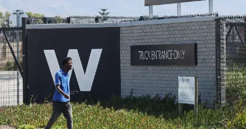 A man walks past the Woolworths truck entrance in Cape Town. File photo.