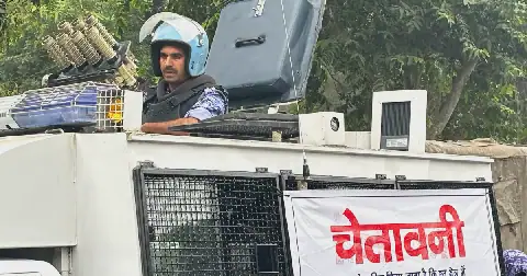 An armored vehicle with a banner warning citizens against unlawful gathering stands near the venue of a youth protest demanding the resignation of the country's election chief Gyanesh Kumar, in New Delhi, India, Saturday, Oct. 10, 2026. (AP Photo/Manish Swarup)