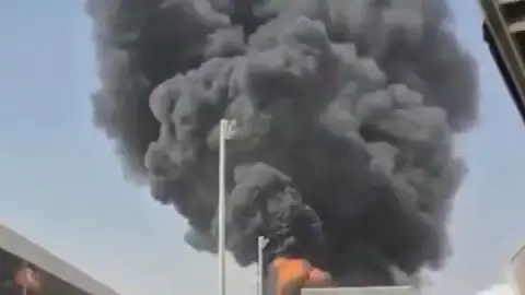 This image from video obtained and verified by AP shows thick black smoke and flames rising from a fire at King Khalid International Airport in Riyadh, Saudi Arabia, Friday, Oct. 9, 2026. (UGC via AP)