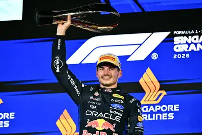 Red Bull Racing's Dutch driver Max Verstappen lifts his trophy as he celebrates on the podium after winning the Formula One Singapore Grand Prix at the Marina Bay Street Circuit in Singapore on Sunday