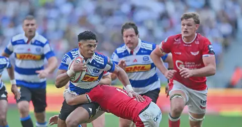 Sacha Feinberg-Mngomezulu of the Stormers is tackled by Ioan Jones of the Scarlets during the United Rugby Championship 2026/27 game at Cape Town Stadium in South Africa on 24 October 2026.
