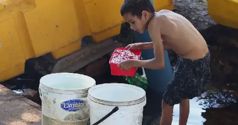 A boy collecting water in Bertrams, Johannesburg, after not having water in the area for days. PHOTO: ANTONIO MUCHAVE.
